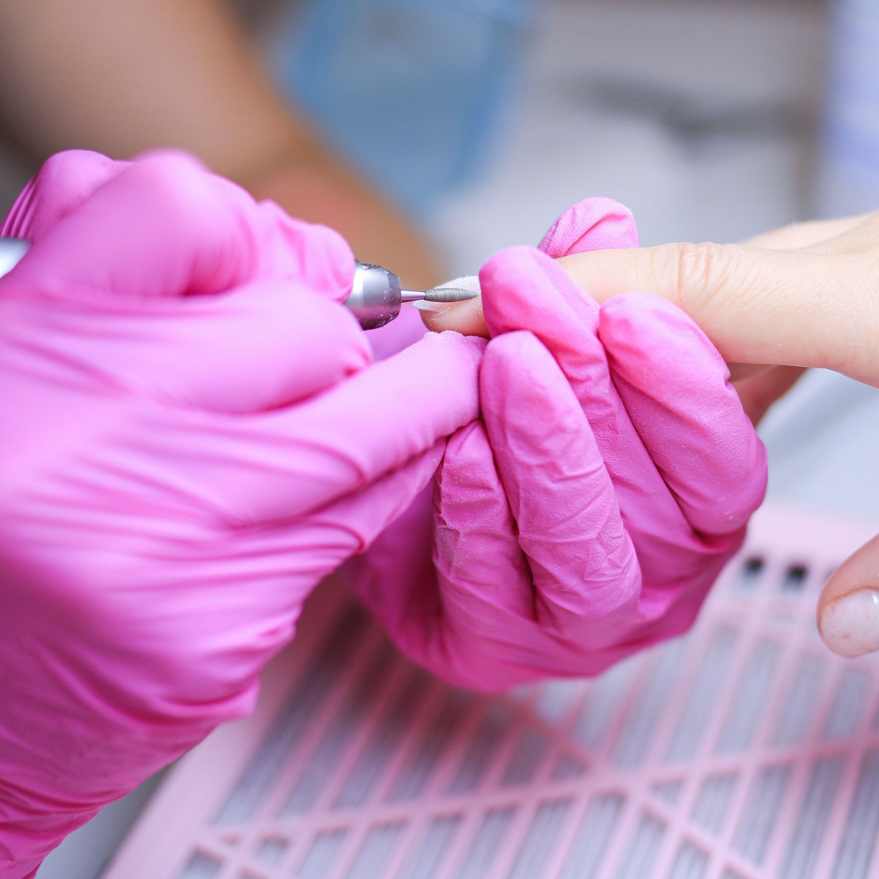 Technician in gloves working on a manicure